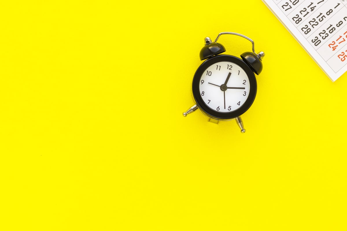 Alarm Clock and Calendar on Yellow Background